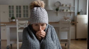 female shiver at freezing flat in warm cap blanket be cause of furnace failing