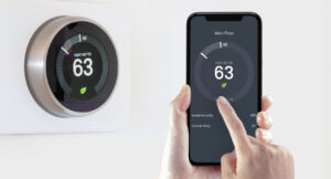 Photo of digital thermostat and corresponding app on mobile phone